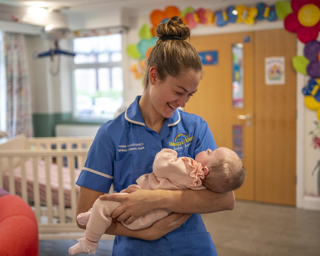 Rebecca House nurse cuddling baby